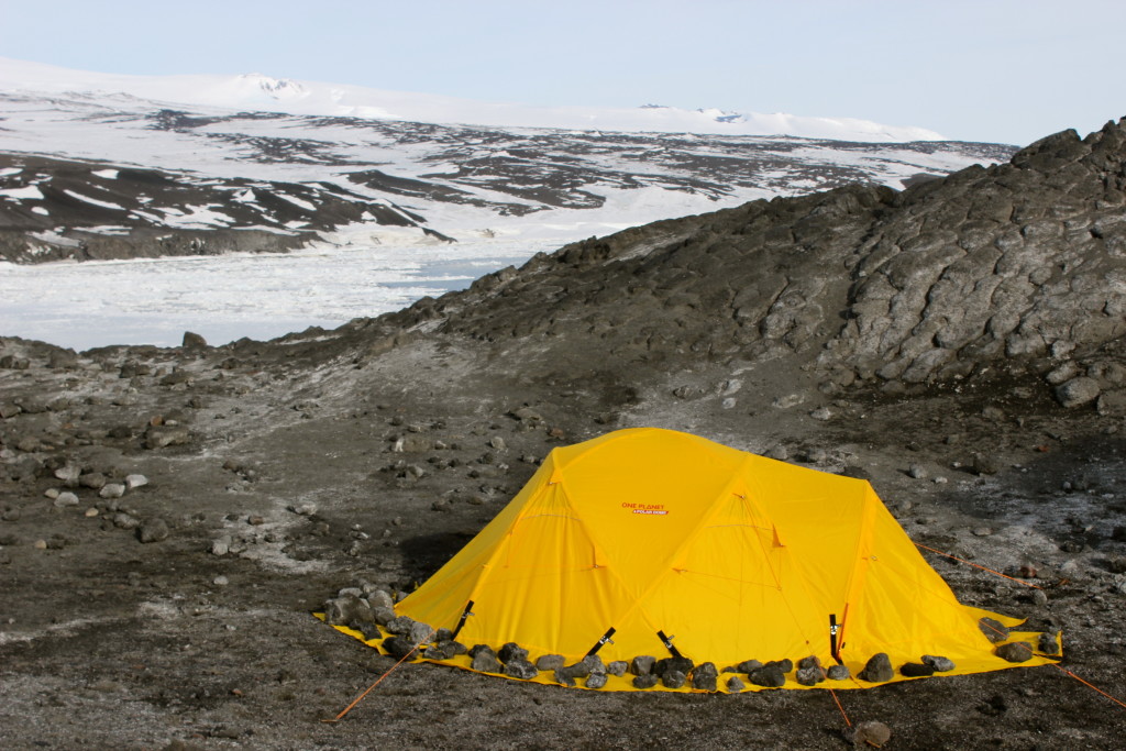 Setting up camp with backdoor bay behind frozen over with sea ice.